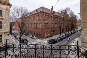 リヴィウにあるLeontovycha 1905の駐車場車を停めた大きなレンガ造りの建物