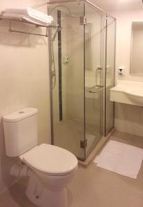 a bathroom with a toilet and a glass shower at Metropolitan YMCA Singapore in Singapore