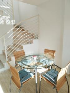 een glazen tafel met 2 stoelen en een trap bij Villa Casa Max - duplex-apartment in Villamartin Golf Resort in Villamartin