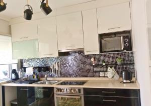 a kitchen with white cabinets and a sink at Estrela do Mar in Gafanha da Nazaré +8 photos