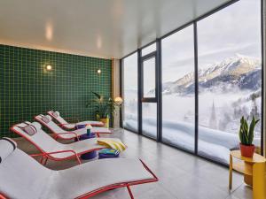 a room with chairs and a view of a mountain at Badeschloss in Bad Gastein