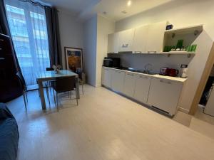 a kitchen and dining room with a table and a counter at Prato Home - apartment near the beach in Menton in Menton