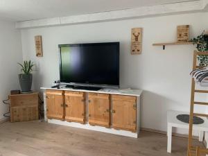 telewizor z płaskim ekranem siedzący na drewnianej szafce w obiekcie Schöne moderne & rustikale Einliegerwohnung mit Küche w mieście Schramberg