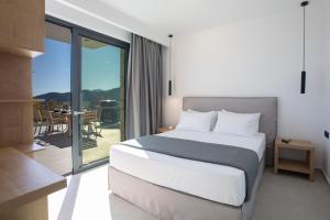sypialnia z łóżkiem i balkonem w obiekcie Oriens Villas w mieście Palaiokhóri