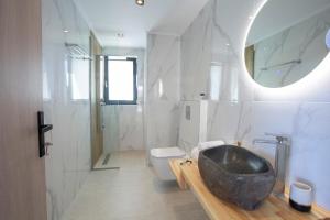W łazience znajduje się umywalka i wanna. w obiekcie Oriens Villas w mieście Palaiokhóri