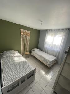1 dormitorio con 2 camas y ventana en Appartement tout équipé 2 chambres + jardin, en Saix