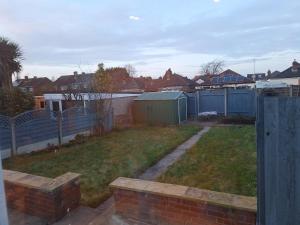 a backyard with a yard with a fence and houses at Uplands Grove Bungalow in Wolverhampton