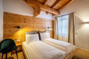 1 dormitorio con 1 cama y 1 silla verde en Mountain Residence Kasern Nr 3, en Predoi