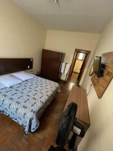 a bedroom with a bed and a desk and a television at Brasil Palace Hotel in Belo Horizonte