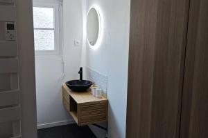 une salle de bain avec un lavabo noir et un miroir dans l'établissement Perle Berckoise - studio - 250m de la plage - 1er étage, à Berck-sur-Mer 19 autres photos