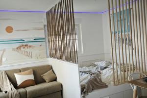 een woonkamer met een bank en een bed bij Perle Berckoise - studio - 250m de la plage - 1er étage in Berck-sur-Mer