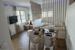 een kamer met een tafel en stoelen en een bed bij Perle Berckoise - studio - 250m de la plage - 1er étage in Berck-sur-Mer