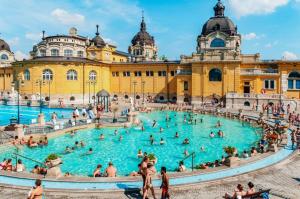 a group of people in a swimming pool in front of a building at Bulb Apartment Budapest in Budapest