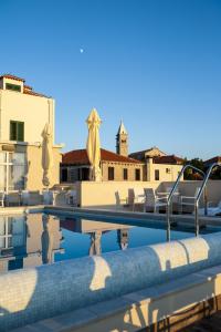 Hotel Konavle في سيليبي: اطلالة المسبح مع الكراسي والمباني