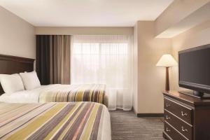 a hotel room with two beds and a flat screen tv at Country Inn & Suites by Radisson, Homewood, AL in Birmingham