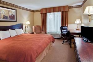 ホット・スプリングスにあるCountry Inn & Suites by Radisson, Hot Springs, ARのベッドとデスクが備わるホテルルームです。