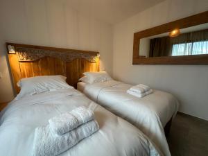 Dos camas en una habitación con toallas. en Résidence UltraMarine en Boucan Canot
