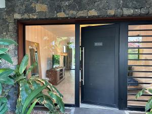 une porte d'entrée noire d'une maison dans l'établissement Résidence UltraMarine, à Boucan Canot