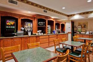 um restaurante com mesas e cadeiras e um bar em Country Inn & Suites by Radisson, Hot Springs, AR em Hot Springs