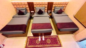 two twin beds in a small room with a rug at The Vacation Villa in Agra