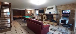 a living room with a couch and a pool table at la longère chez marc et antoinette 