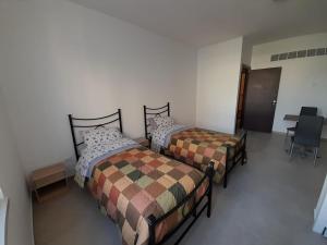 two beds in a room with a table and chairs at Irpinia Verde in Mirabella Eclano