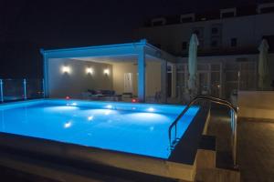 ein nachts beleuchtetes Schwimmbecken in der Unterkunft Hotel Konavle in Čilipi