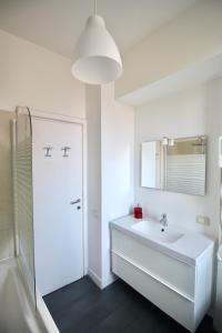 uma casa de banho branca com um lavatório e um espelho em Calisto 6 em Roma