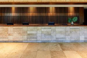 a lobby with a counter with a potted plant at Radisson Blu Plaza El Bosque Santiago in Santiago