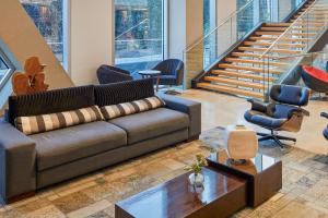 a living room with a couch and chairs and stairs at Radisson Blu Plaza El Bosque Santiago in Santiago