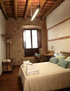 1 dormitorio con 2 camas, mesa y ventana en casa rural Cieza de León, en Llerena