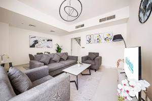 a living room with a couch and a table at Aliving Luxury 3BR Villa With Maid Room Damac Hills 2 in Dubai