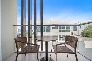 a table and two chairs on a balcony at Aliving Luxury 3BR Villa With Maid Room Damac Hills 2 in Dubai +10 photos