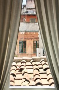 uma vista para um telhado de azulejos a partir de uma janela em Calisto 6 em Roma