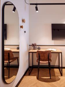 a mirror in a room with a table and chairs at Hotel Antica Fonte in Brescia