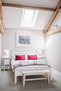 a bedroom with a white bed with red pillows at The Old Granary in Barnetby le Wold