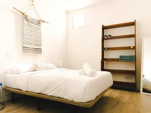 Schlafzimmer mit einem Bett mit weißer Bettwäsche in der Unterkunft Agüita Surf Lodge in Las Palmas de Gran Canaria