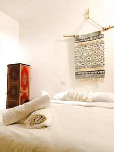 1 Schlafzimmer mit 2 Betten und weißer Bettwäsche in der Unterkunft Agüita Surf Lodge in Las Palmas de Gran Canaria
