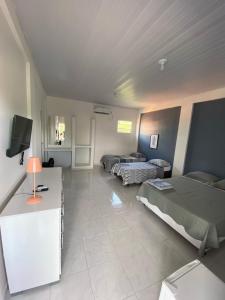 salon z 2 łóżkami i telewizorem w obiekcie Asas da Maré Pousada w mieście Bragança