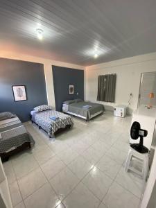 Habitación grande con 2 camas y mesa. en Asas da Maré Pousada, en Bragança