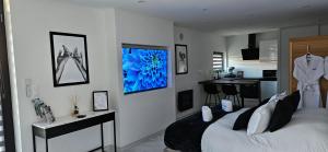 a bedroom with a bed and a kitchen in it at Loft Détente & Spa du Tram in Ronchamp