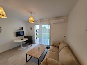 ein Wohnzimmer mit Sofa und Tisch in der Unterkunft Superbe appartement vue mer terrasse couverte face à la mer in Linguizzetta