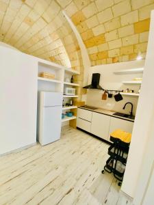 a kitchen with a white refrigerator and a table at La Bitta Suite in Brindisi
