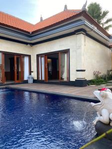 a house with a swimming pool in front of a house at Villa Ole in Ubud
