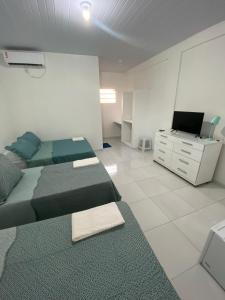 Habitación con 2 camas y escritorio con TV. en Asas da Maré Pousada, en Bragança