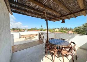 a patio with a table and chairs on a roof at Casa Branca BG in Barra Grande