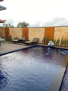 a swimming pool with two chairs at Villa Ole in Ubud