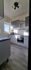 eine Küche mit weißen Geräten und einem Deckenventilator in der Unterkunft Zweibettzimmer "Grau" in zentraler Lage in Bremen