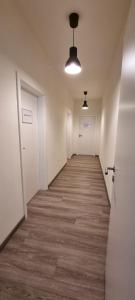 an empty hallway with white doors and wooden floors at Zweibettzimmer "Grau" in zentraler Lage in Bremen