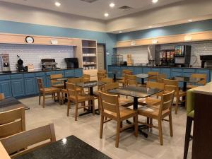 une salle à manger avec des tables et des chaises dans un restaurant dans l'établissement Country Inn & Suites by Radisson, Kalamazoo, MI, à Kalamazoo